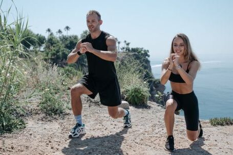 Compound Exercises - A Man and Woman Working Out Near the Cliff