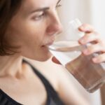 Drink Water - woman in black tank top drinking water