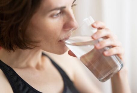 Drink Water - woman in black tank top drinking water