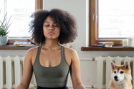 Home Workouts - Woman Meditating Beside her Dog