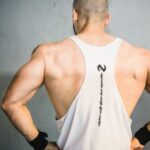 Build Muscle - Backview of Brawny Man with Broad Shoudlers in White Tank Top