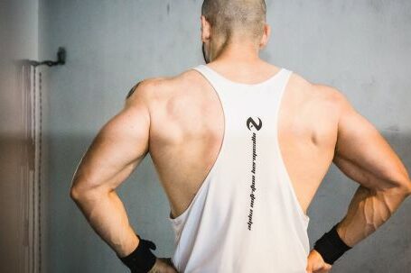 Build Muscle - Backview of Brawny Man with Broad Shoudlers in White Tank Top