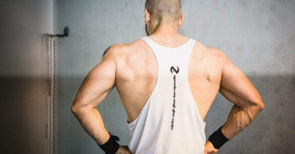 Build Muscle - Backview of Brawny Man with Broad Shoudlers in White Tank Top