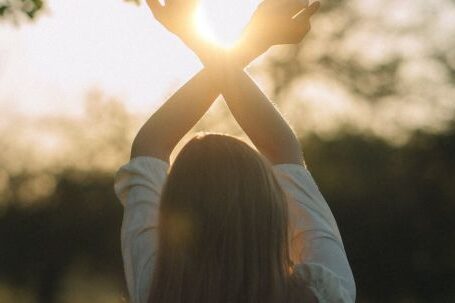 Stretching Integration - Young Woman Standing on the Meadow Stretching Her Arms Towards Rising Sun