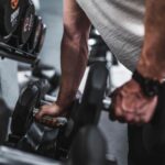 Exercise - person in gray shirt holding black dumbbell