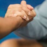 Joint-friendly Workouts - Anonymous couch supporting obese woman resting on floor during training in gym