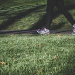 Exercise - shallow focus photography of person walking on road between grass