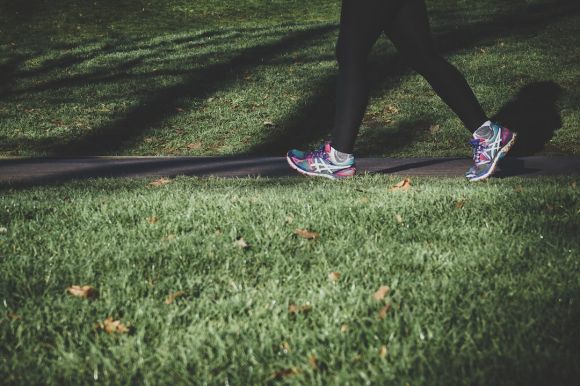 Exercise - shallow focus photography of person walking on road between grass