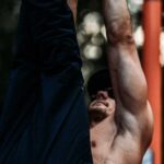 Toned Exercises - Toned Man Training on Bar Outdoors