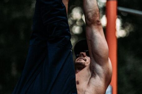 Toned Exercises - Toned Man Training on Bar Outdoors